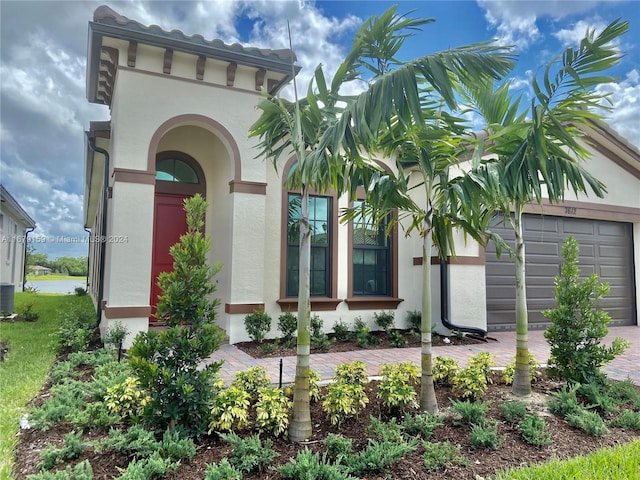 entrance to property featuring cooling unit and a garage