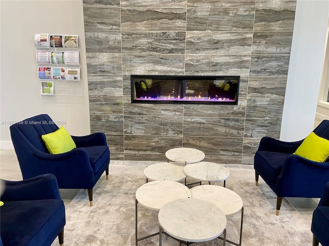 sitting room featuring a tiled fireplace