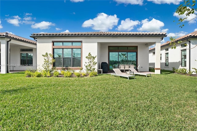 back of house with a patio and a lawn