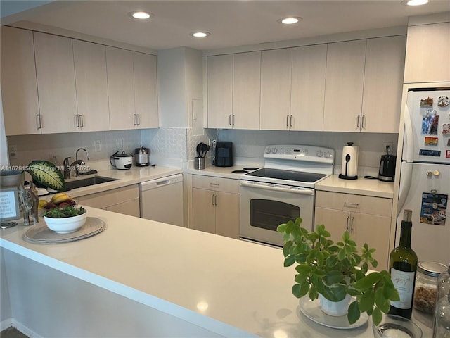 kitchen with white appliances, recessed lighting, a sink, light countertops, and backsplash