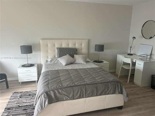 bedroom featuring baseboards and wood finished floors