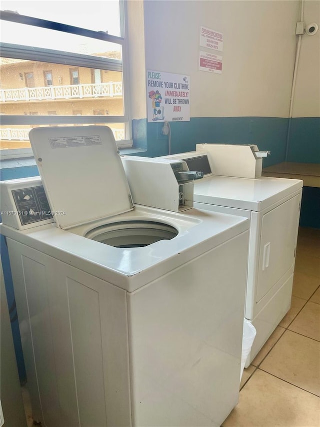 clothes washing area with independent washer and dryer and light tile patterned floors