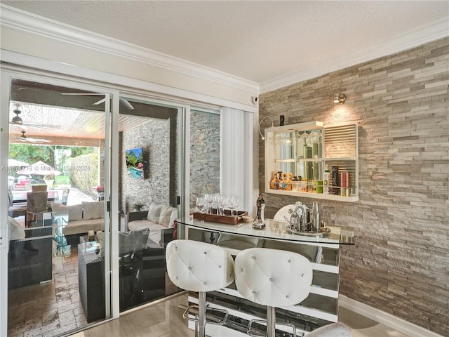 interior space with bar area and ceiling fan