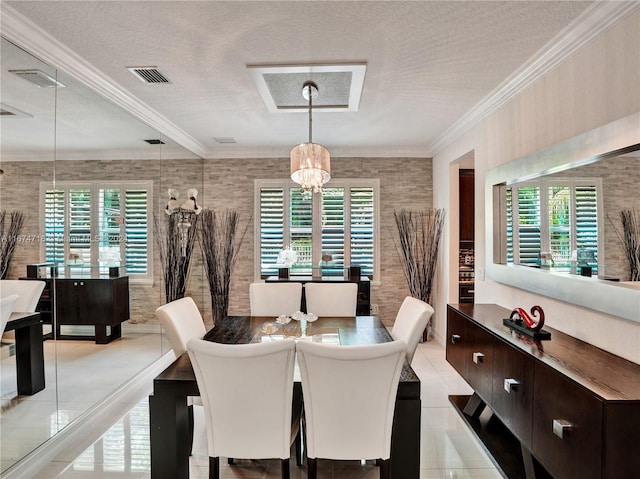 tiled dining space with a notable chandelier, a healthy amount of sunlight, a textured ceiling, and ornamental molding