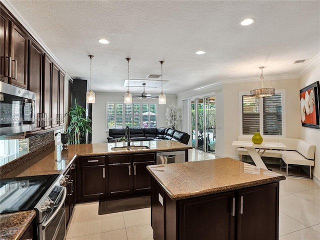 kitchen featuring sink, a kitchen island, stainless steel appliances, pendant lighting, and crown molding