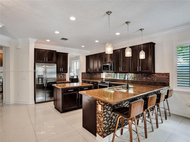 kitchen with a kitchen breakfast bar, kitchen peninsula, backsplash, decorative light fixtures, and appliances with stainless steel finishes