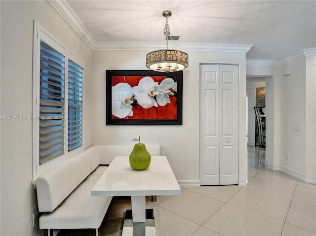 dining space featuring breakfast area, crown molding, a textured ceiling, and light tile patterned flooring