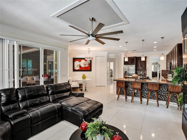 living room featuring ornamental molding, ceiling fan, a textured ceiling, and light tile patterned floors