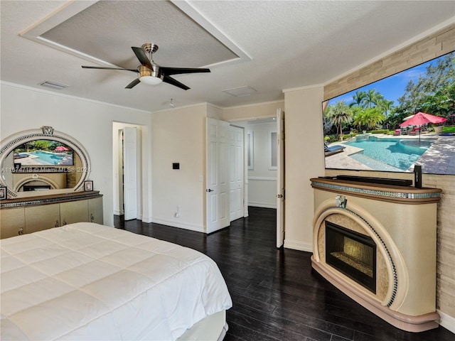 bedroom with dark wood-type flooring, ceiling fan, crown molding, and a textured ceiling