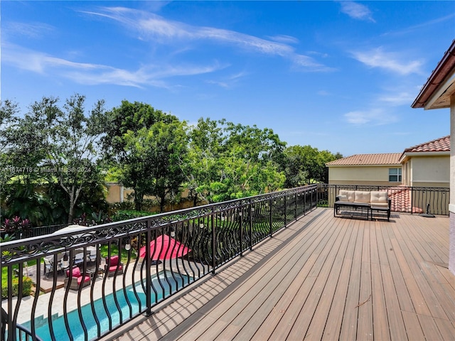 deck featuring a fenced in pool and an outdoor hangout area