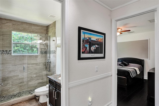 bathroom featuring ceiling fan, a shower with door, toilet, vanity, and tile patterned floors