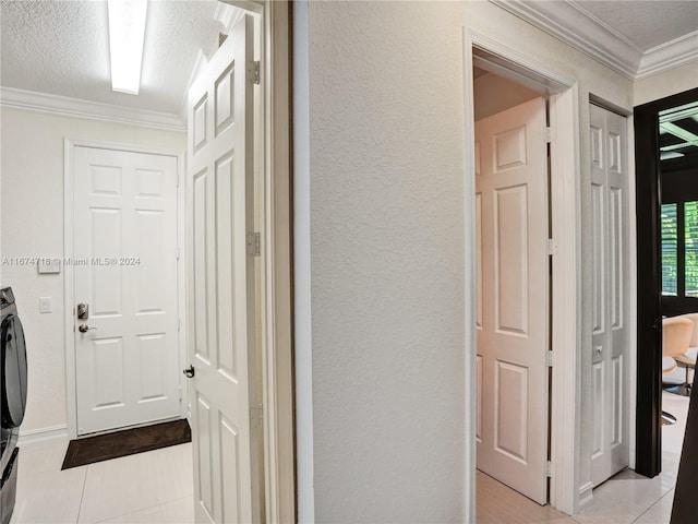 corridor featuring a textured ceiling, ornamental molding, and light tile patterned floors