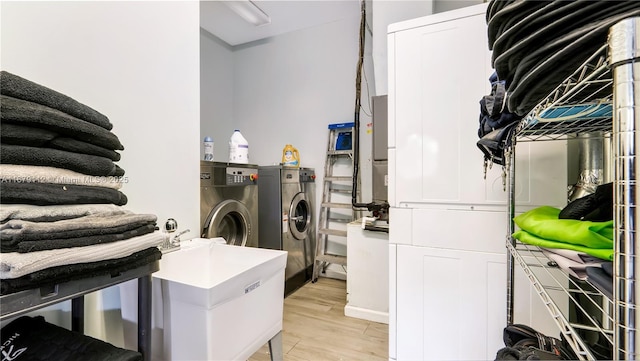 laundry room with sink, light hardwood / wood-style flooring, and independent washer and dryer