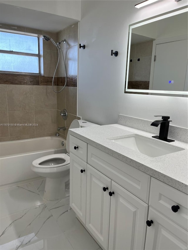 full bathroom featuring toilet, tiled shower / bath combo, and vanity