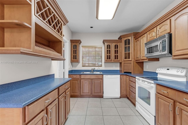 kitchen featuring sink, light tile patterned floors, and white appliances