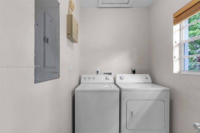 clothes washing area with electric panel and washer and dryer