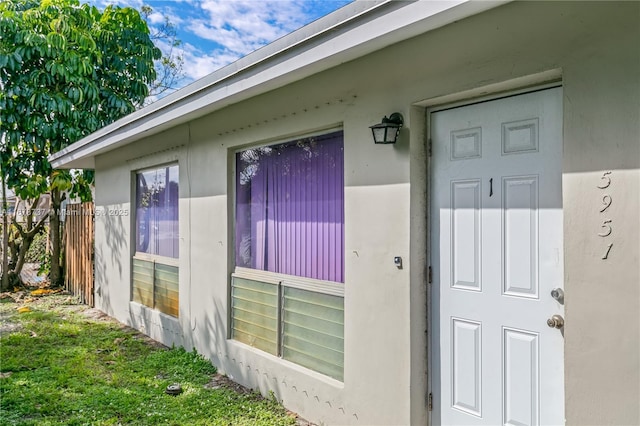 doorway to property with a lawn