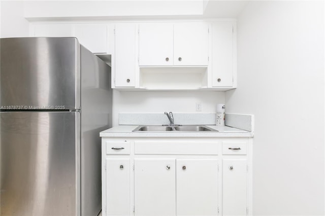 kitchen with white cabinets, stainless steel fridge, and sink