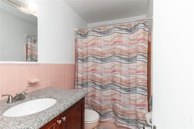 bathroom featuring toilet, tile walls, walk in shower, and vanity