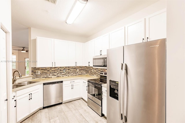 kitchen featuring sink, light hardwood / wood-style flooring, ceiling fan, appliances with stainless steel finishes, and white cabinetry