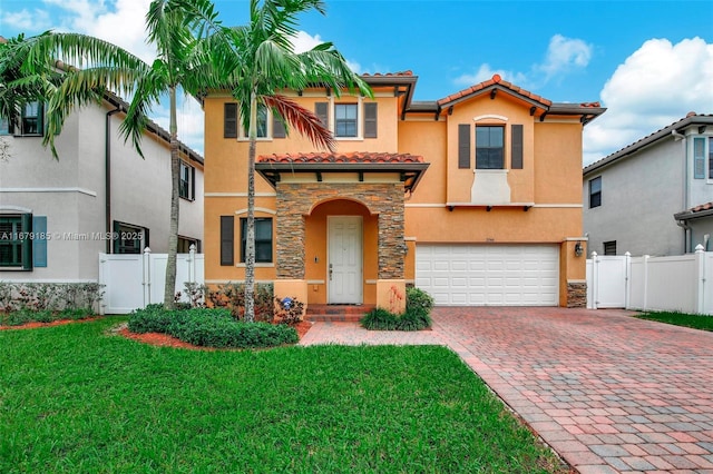 mediterranean / spanish-style home with a garage and a front lawn