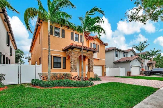 mediterranean / spanish home featuring a front lawn and a garage