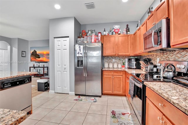 3544 W 94th St, Hialeah, FL 33018 - kitchen with stainless steel appliances, arched walkways, tasteful backsplash, light tile patterned floors, and light stone countertops