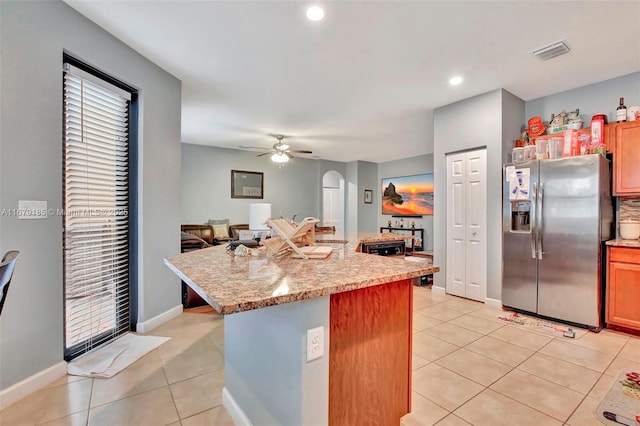 3544 W 94th St, Hialeah, FL 33018 - kitchen with stainless steel fridge with ice dispenser, arched walkways, light tile patterned floors, ceiling fan, and a center island