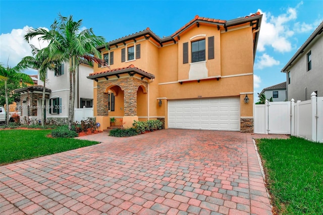 3544 W 94th St, Hialeah, FL 33018 - mediterranean / spanish-style house with a garage, decorative driveway, stucco siding, a gate, and stone siding