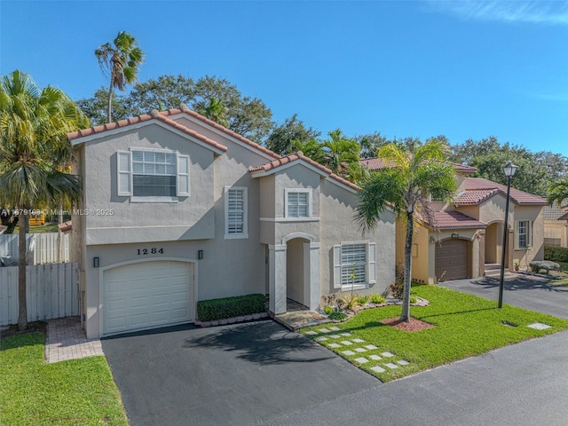 mediterranean / spanish home with a front yard and a garage