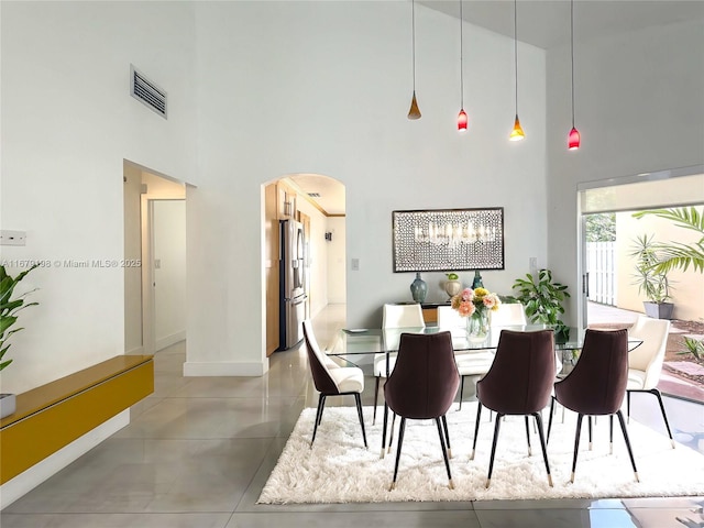 dining area featuring a towering ceiling