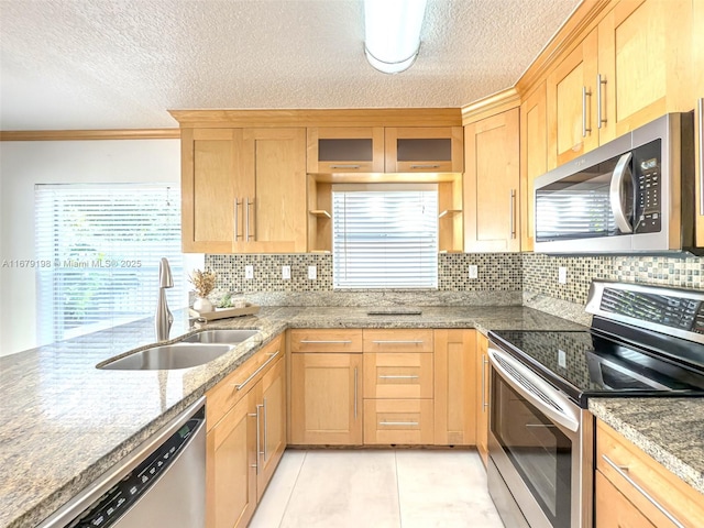 kitchen featuring appliances with stainless steel finishes, light tile patterned floors, decorative backsplash, a textured ceiling, and sink