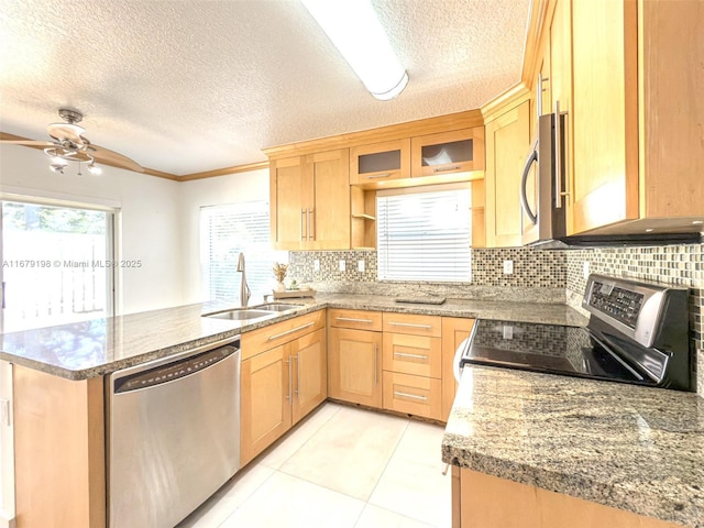 kitchen featuring sink, a textured ceiling, light tile patterned floors, kitchen peninsula, and appliances with stainless steel finishes