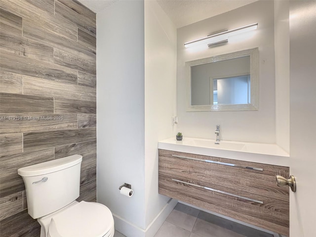 bathroom featuring a textured ceiling, tile patterned flooring, vanity, and toilet