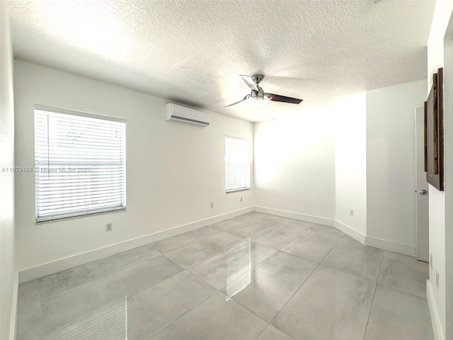 unfurnished room with a textured ceiling, a wall unit AC, and ceiling fan