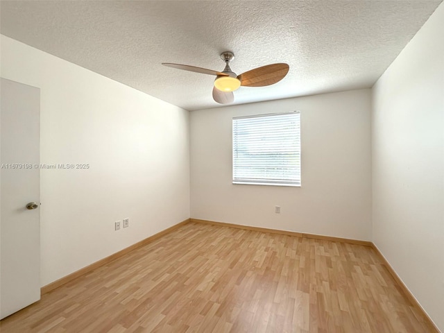 spare room with a textured ceiling, light wood-type flooring, and ceiling fan