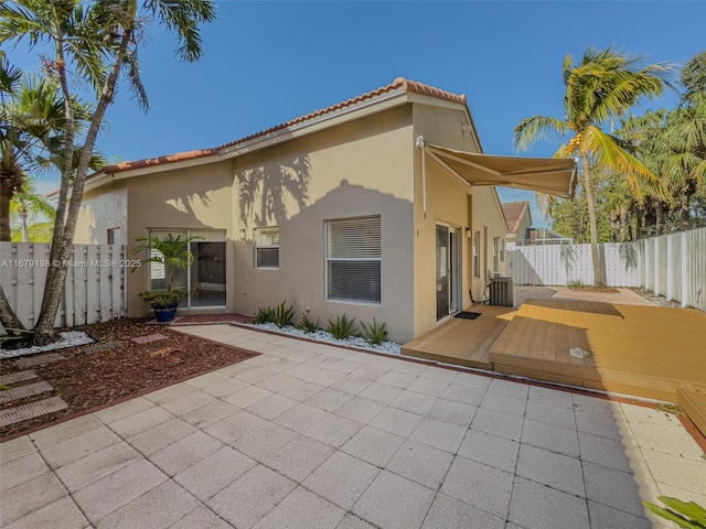 back of property featuring central air condition unit, a deck, and a patio area