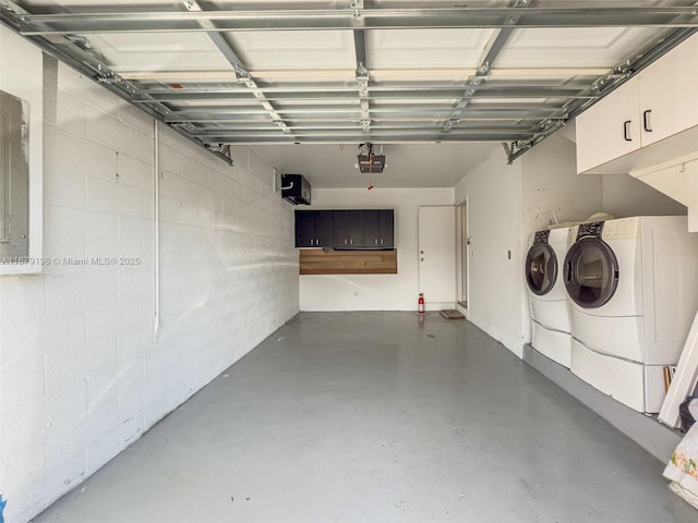 garage with independent washer and dryer and a garage door opener