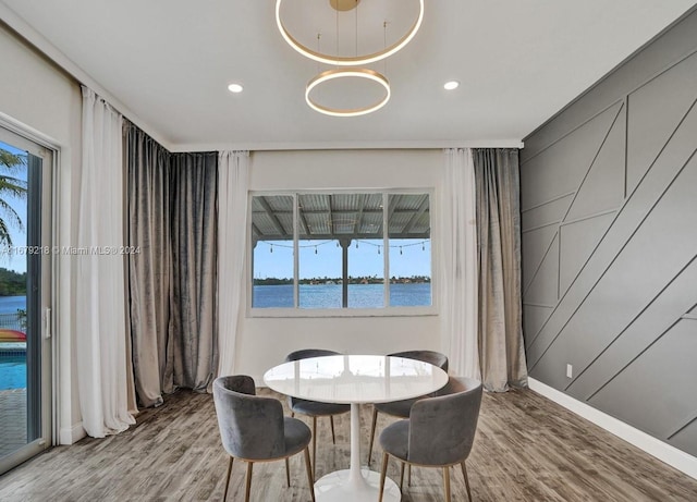 dining area featuring a water view, hardwood / wood-style flooring, and plenty of natural light