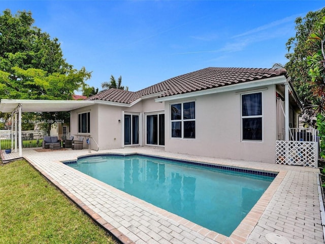 back of property with a fenced in pool and a patio area