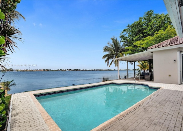 view of swimming pool featuring a patio and a water view