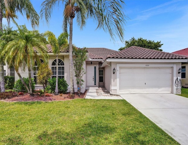 mediterranean / spanish home featuring a front lawn and a garage