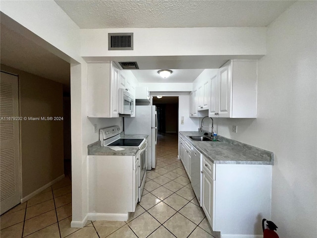 kitchen featuring sink, white cabinetry, white appliances, and light tile patterned floors