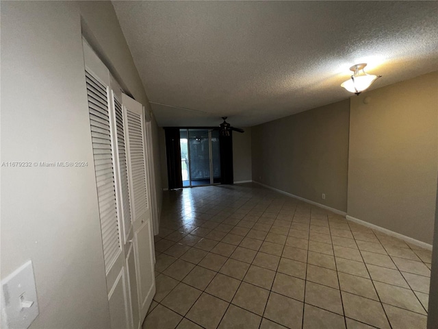 unfurnished room featuring ceiling fan, a textured ceiling, and tile patterned flooring