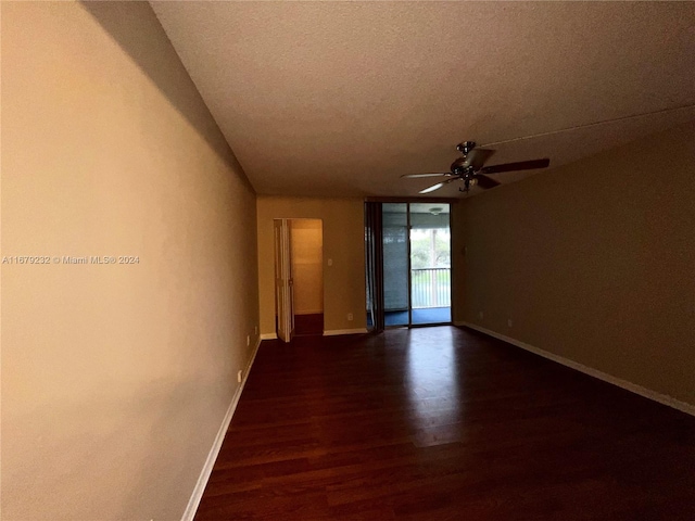 unfurnished room with dark wood-type flooring, ceiling fan, and a textured ceiling