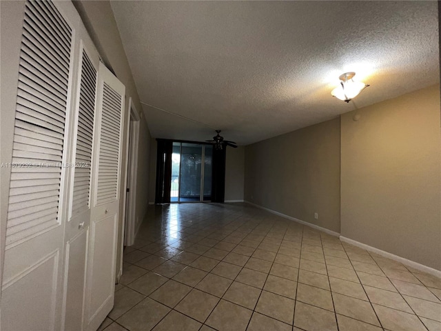 spare room featuring a textured ceiling, tile patterned floors, and ceiling fan