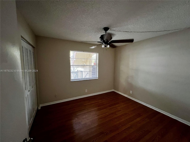 unfurnished bedroom featuring dark wood-type flooring, a textured ceiling, a closet, and ceiling fan