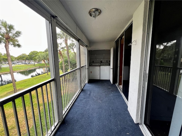 unfurnished sunroom featuring a water view and washing machine and clothes dryer