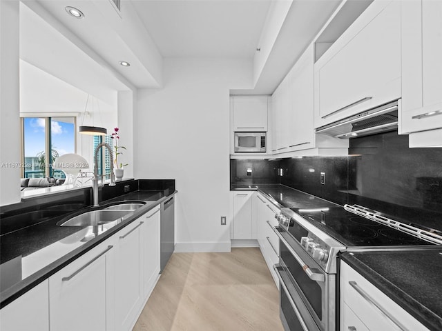 kitchen with light hardwood / wood-style flooring, stainless steel appliances, sink, and white cabinets