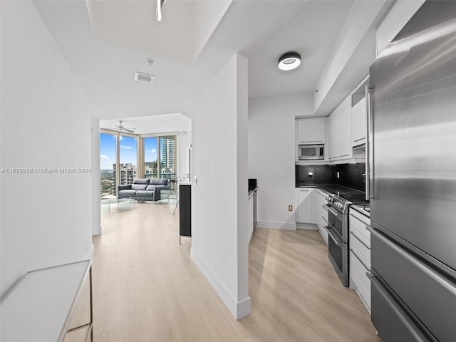 kitchen featuring decorative backsplash, ceiling fan, white cabinetry, light hardwood / wood-style flooring, and stainless steel appliances